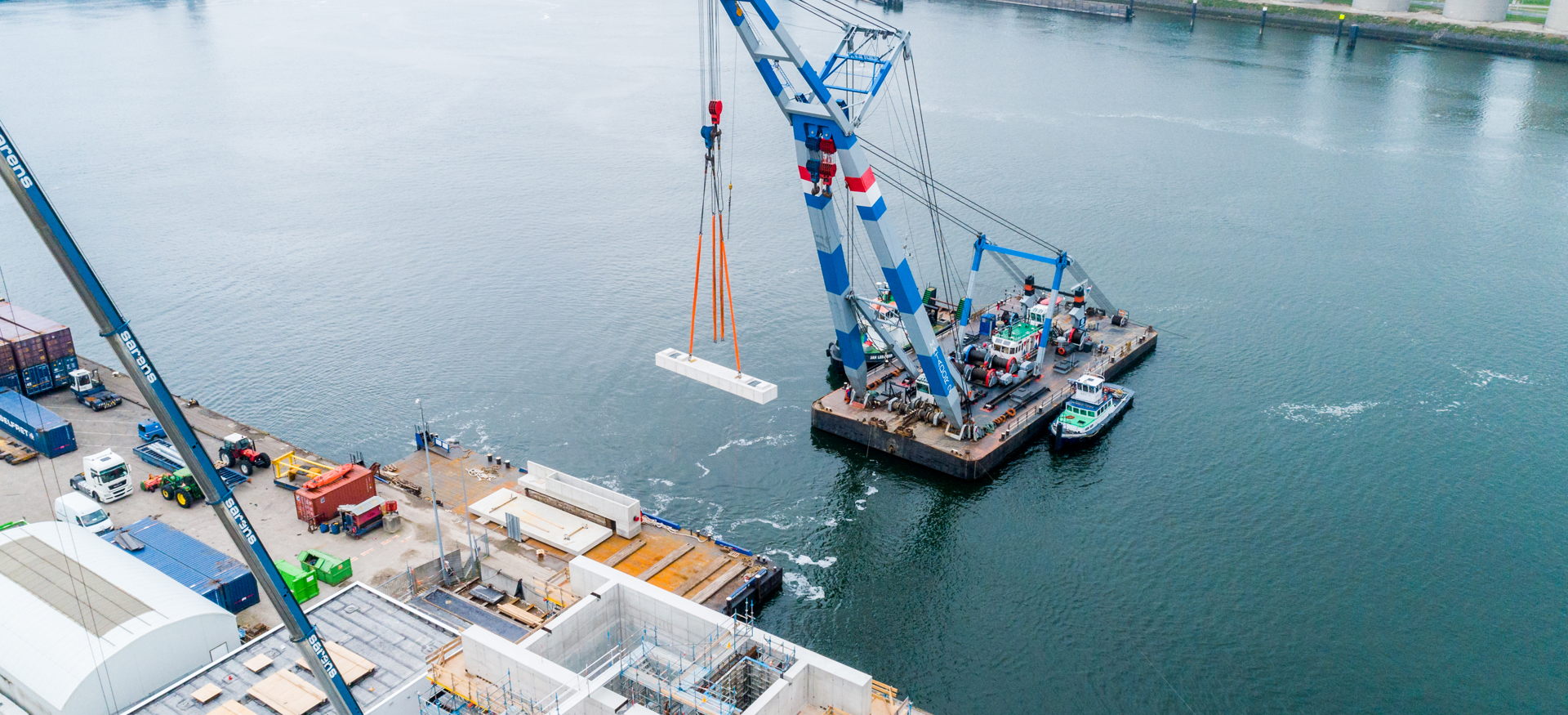 Een drone shot waarbij een gedeelte van het Vopak FireWater Pumphouse op zijn plek wordt gehesen op het water. 