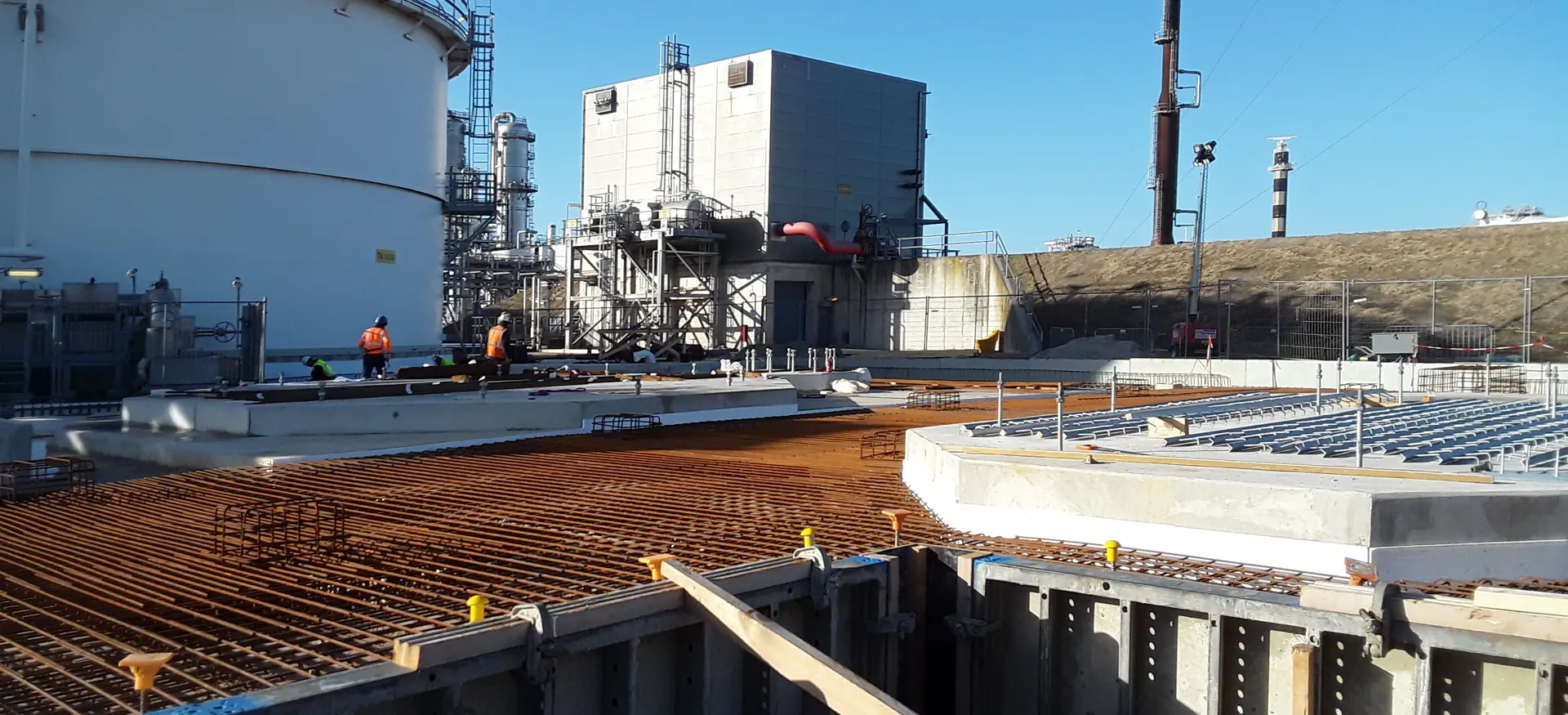 Staalconstructie van het Waste Water Treatment Project met op de achtergrond een silo en een gebouw